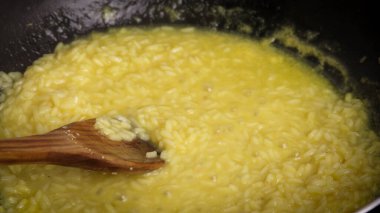 Tavada safran risotto pişirmek.