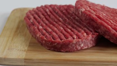 Tahtadaki çiğ sığır eti burgerlerini kapatın.
