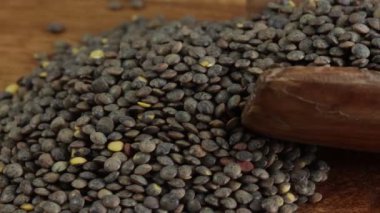 Tahta kaşıkta çiğ yeşil mercimek yığınını kapat.