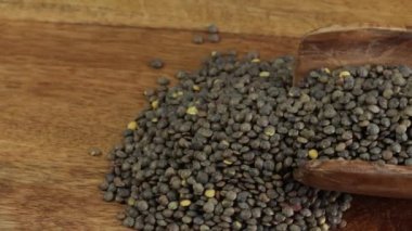 Tahta kaşıkta çiğ yeşil mercimek yığınını kapat.