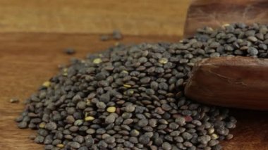 Tahta kaşıkta çiğ yeşil mercimek yığınını kapat.