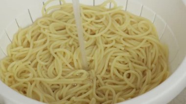 Soğutmak için spagettiye soğuk su döktü.