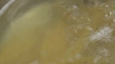 Spagetti kaynayan bir tencerede pişiriliyor.