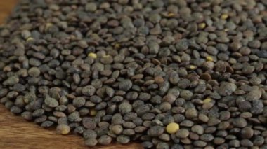 Tahta masadaki çiğ yeşil mercimek yığınını kapat.