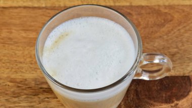 Bir fincan kapuçino yakın plan, masanın üstünde.