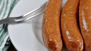 Tütsülenmiş sosisler yakın planda, bir tabakta.