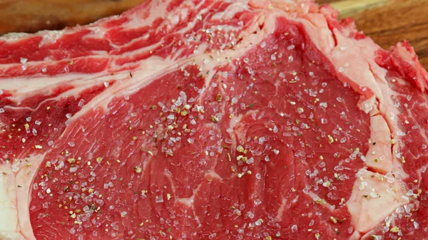 牛肉の生の肋骨の上に塩とスパイスを注ぎ — ストック写真