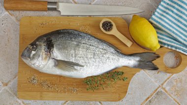 Tüm çipura, yakın plan, kesme tahtasında.