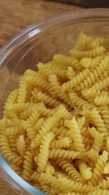 Çiğ fusilli makarna, yakın plan, bir tabakta.