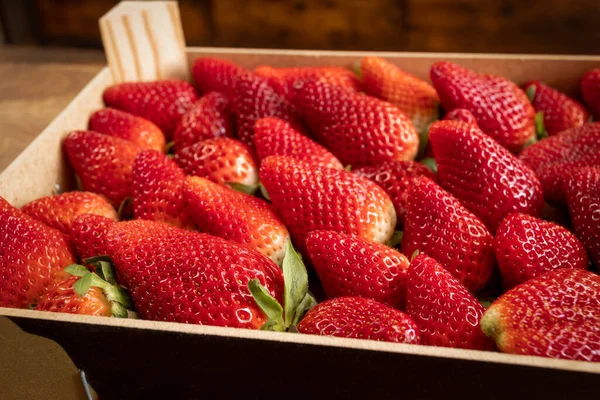 stock image box of strawberries, close-up, on a wooden table