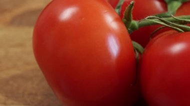 Kırmızı domates kümesi, yakın plan, kesme tahtası üzerinde.