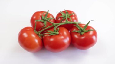 Bir grup kırmızı domates, yakın plan, beyaz arka planda izole edilmiş.