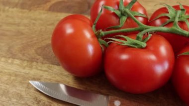 Kırmızı domates kümesi, yakın plan, kesme tahtası üzerinde.