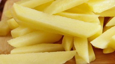 Çiğ patates kızartması yığını, yakın plan, masanın üstünde.