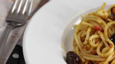 Spagetti deniz ürünleriyle pişirilmiş, yakın plan, bir tabakta.