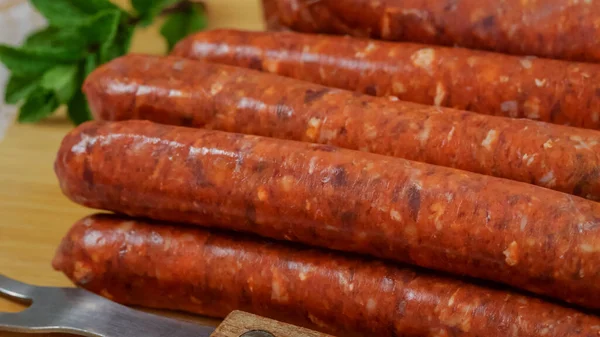 Birkaç çiğ merguez sosisi, yakın plan, kesim tahtasının üzerinde.