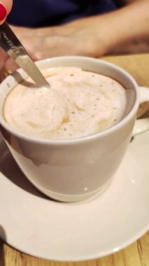 Bir fincan karışık latte ile kaşığı yakın.