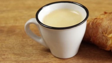 Bir fincan kahve ve kruvasan. Yakın çekim.