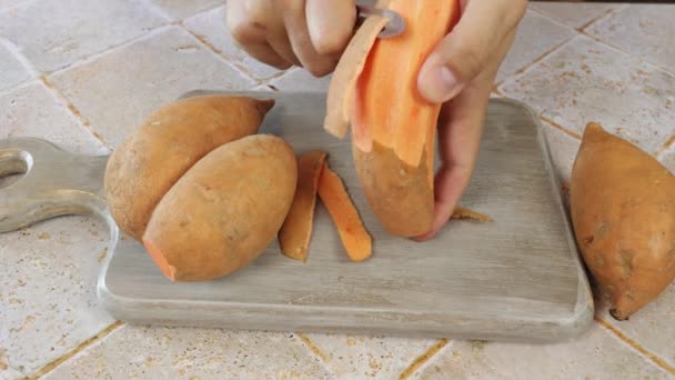 Een Persoon Die Een Zoete Aardappel Schilt — Stockvideo
