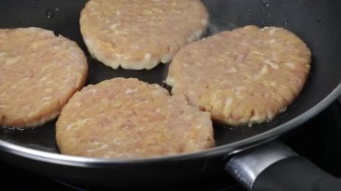 chicken burgers cooking in a frying pan