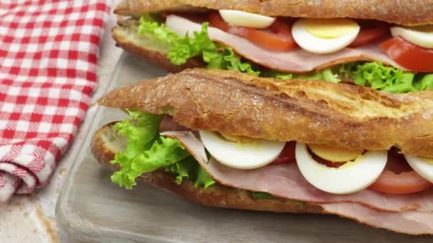 Primer Plano Dos Sándwiches Jamón Verduras Crudas Una Tabla Cortar — Vídeo de stock