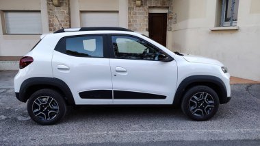 Vaison la Romaine, Vaucluse, Fransa - 07262023: kaldırımın kenarına park edilmiş beyaz bir Dacia Spring marka arabanın yan görüntüsü
