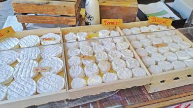 Pazarda koyun peyniri satışı. Fransızca yazılmış kelimeler. Koyun, çiftçi, buket.