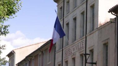 Bir belediye binasının ön cephesinde Fransız bayrağı dalgalanıyor.