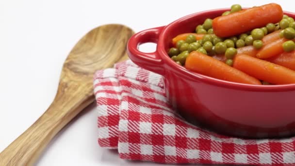 白い背景に隔離された皿の中の豆とニンジン — ストック動画