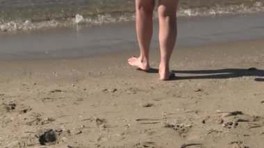 Sahilde yürüyen bir kadın