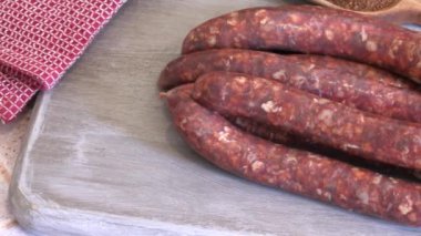 Bir demet çiğ merguez, yakın plan, kesim tahtasında.