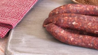 Bir demet çiğ merguez, yakın plan, kesim tahtasında.