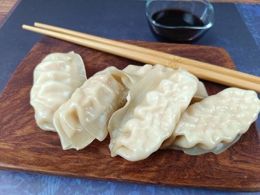 Tahta bir tabakta birkaç gyoza.