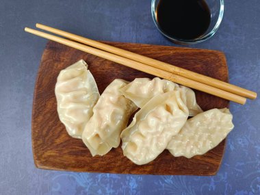 Tahta bir tabakta birkaç gyoza.