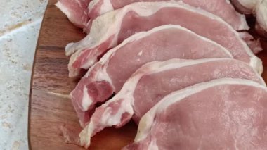 Kesme tahtasına kesilmiş çiğ domuz filetosu.