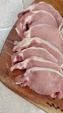 Kesme tahtasına kesilmiş çiğ domuz filetosu.