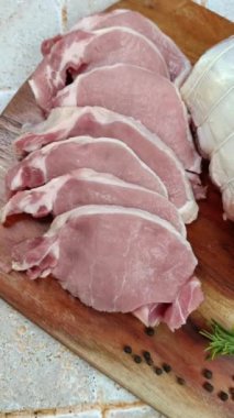 Kesme tahtasına kesilmiş çiğ domuz filetosu.