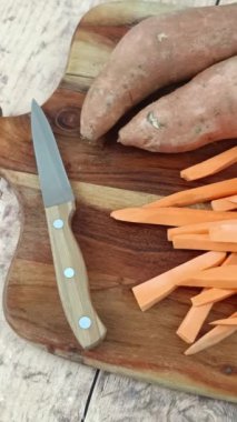 Kesme tahtasındaki çiğ patates kızartması yığını.