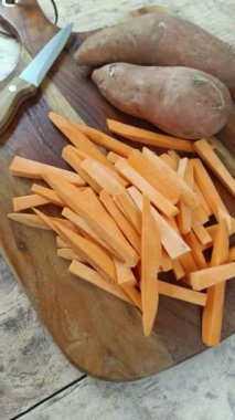 Kesme tahtasındaki çiğ patates kızartması yığını.