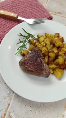 Yakın planda pişmiş et ve patates parçaları.