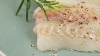 Biber ve tuz çiğ hake filetolarının üzerine döküldü.