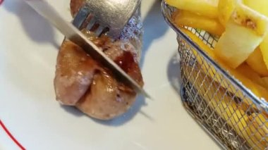 Bıçak ve çatalla kesilmiş bir andouillette 'in yakın çekimi.