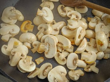 Tavada pişen düğmeli mantarlar