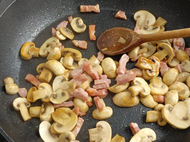 Düğme mantarı ve tavada pişmiş domuz pastırması.