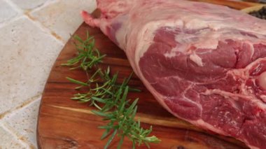 Çiğ kuzu bacağı, yakın plan, kesme tahtasında.