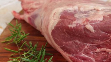 Çiğ kuzu bacağı, yakın plan, kesme tahtasında.