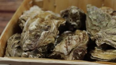 Bir sepet istiridye, yakın plan, masanın üstünde.