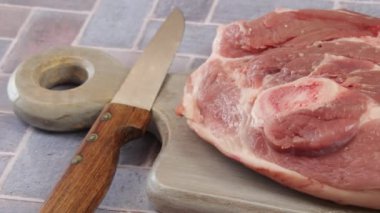 Kesme tahtasındaki çiğ domuz bıçağı.