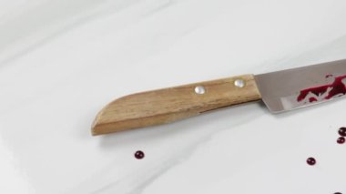Ev kazası: Mutfak bıçağı ve kan, yakın plan, mutfak masasının üzerinde..