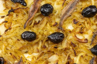 Pissaladire dilimlere ayrılmış, yakın plan, masanın üzerinde.